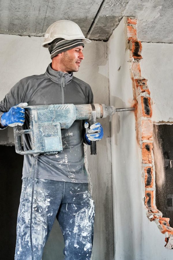 Side view of man builder in workwear drilling wall with hammer drill. Male worker using drill breaker while destroying wall in apartment under renovation. Demolition work and home renovation concept. SSUCv3H4sIAAAAAAAACnRTwW7cIBC9V+o/WJxjaW3w2s61px4q9V71MIbxLgqGFeBUUZR/72DsDanSG7w384Y3M7x+/VJVbIKgJXusXtON7tqYNUQPUTtL8Olhxz1ahb5Enj0/n0oAlY7OazAlOEGUVwsLEmhXYxL8tpEsRIhrwJCq75CEiBfSyOBdIj/xV75XB7GRlEEU+4nuZpA9FExYp8T80EGiMWDRrYEdfK73H7HvVqUeJCefCH5zlshVbh266+XD78M2XNDKl3cTCVJuwhCdfCq9ENGcuu58VzokiFAeYQlRb837kEGN/yQeDCwv/4R+cKDkxHl/hnocB14LmHk9nEVfI4qO96PoJhzehfNhc7aPx6NByBPba5ArPgwj9rVCKWuBSVx1Q922clSy7QWfsmR+J3v6E9Ev5cxhVdoV4352EkwK4EXlm9dS20uR5uJ128cjTbrVRp/s3z0z49wNJtqLx2omTTzwK4RA4erAi0KSJu+Woo51cTO8qzJFK5quDW9H0XBBn+BEPeQ93wPyWl816WzPOYS20WtVWtfpBaybBfKmpcbNHGrRD20Np7FPJzHLZug49NTCt78AAAD//wMASGnCArEDAAA=